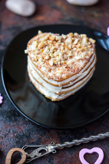 Beautiful heart cake ready to eat on black plate.