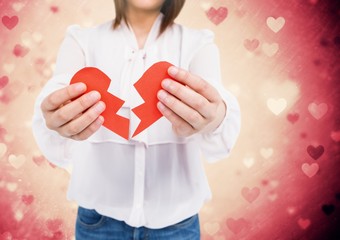 Mid-section of a woman holding a broken heart