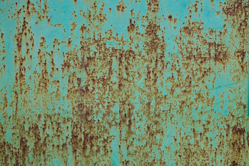 Green paint peeling off a metal plate, background.