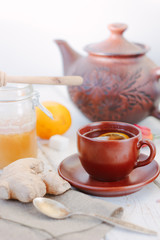Ginger tea with lemon, lime and honey on white.