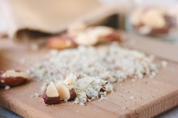 Brazil nuts on wooden board chopped by chief knife
