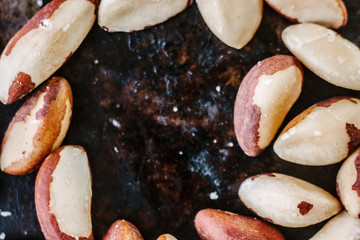 Brazil nuts on black metal board.