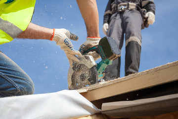 Installing a skylight. Construction Builder Worker use Circular Saw to Cut a Roof Opening for window