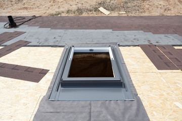 Installing window skylight on a roof with Asphalt Shingles or Bitumen Tiles under construction