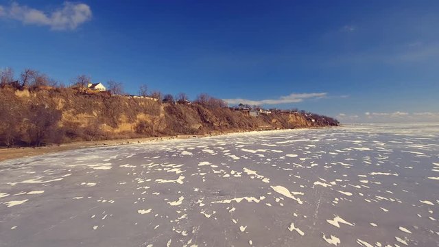 Flying over sea. Frozen sea covered with a thick layer of ice. Aerial view.