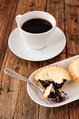 A Turkish coffee set with Cezve mince pies and white cup, served on wooden table