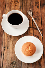 A Turkish coffee set with Cezve muffin and white cup, served on wooden table