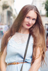Beautiful Woman with long Hair is walking by City Streets - Happy People Concept - Summer Sunny Photo