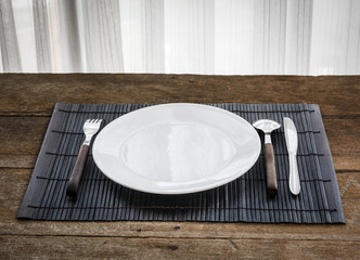 spoon, fork, knife and white dish on Platemat