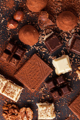 Delicious chocolates and spices on a black background.