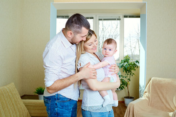 Fototapeta premium Baby with mom and dad smiling laughs in the room