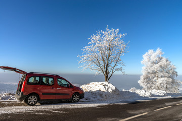 Fototapeta premium Car on the winter road in mountains. Sunny day. Picturesque and