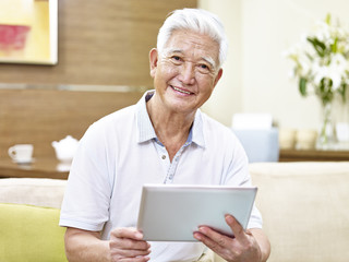 Fototapeta na wymiar senior asian man using tablet computer