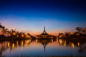 Fototapeta na wymiar Night garden with central building landscape view reflection on water at twilight time , the garden is located at bangkok thailand