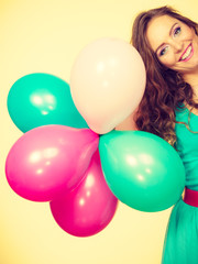 Woman holding bunch of colorful balloons