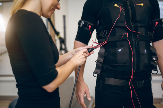 Female trainer connecting cables of ems suit
