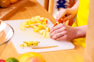 Woman housewife in kitchen cutting apple fruits