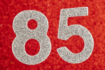 Number eighty-five silver color over a red background. Anniversa