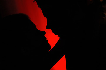 Couple kissing silhouetted in red