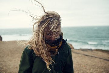 Portrait of woman at beach with windswept hair, Long Island, New York, United States of America 