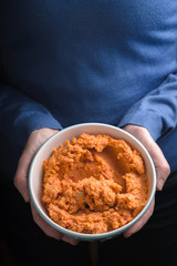 Bowl with hummus on the hands