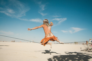 Man jumping from hot desert sand 