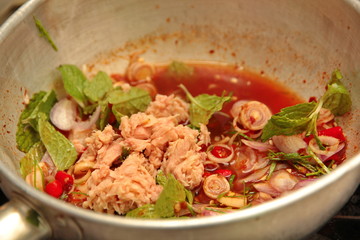 Spicy and sour mixed herb salad with tuna served .