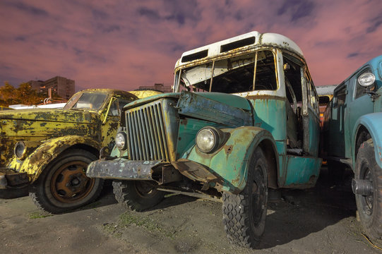 Old broken retro bus on a car graveyard