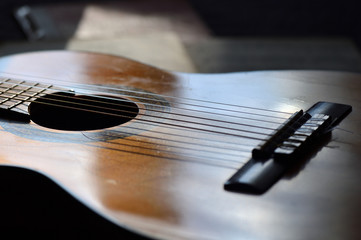 The old guitar and music books illuminated by the sun