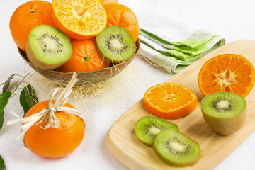 Fresh citrus fruits mandarin, orange and kiwi fruit in a rustic style close-up