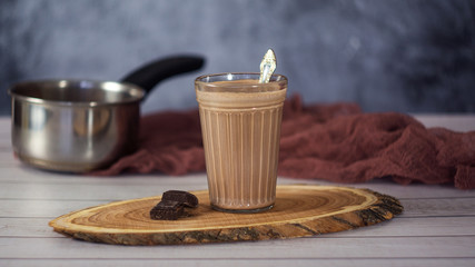 Cocoa drink in glass on wooden background