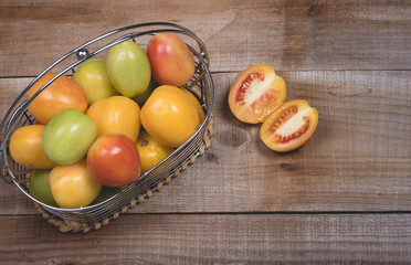 Tomatoes in a natural basket on a rushtic wooden background