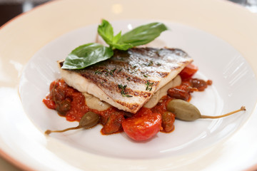 Sea bass fillet with tomato sauce and capers