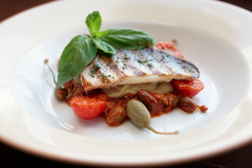 Sea bass fillet with tomato sauce and capers