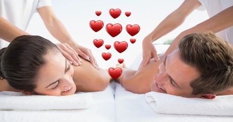 Masseur giving massage to couple at spa