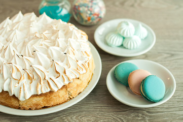Sponge cake and macaroon cake on the table. Wooden background, banner for confectionery