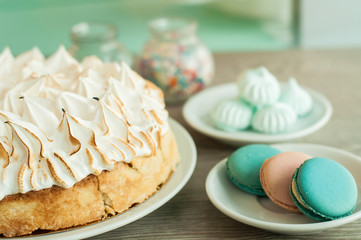 Sponge cake and macaroon cake on the table. Wooden background, banner for confectionery
