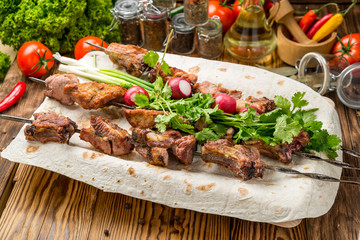 Assorted delicious grilled meat with vegetable on white plate  picnic table for family bbq party