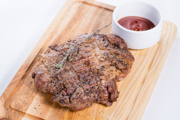 big steak on a wooden board with sauce