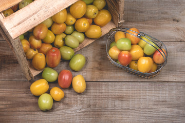 Tomatoes in a natural basket on a rushtic wooden background