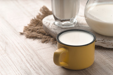 Glass, pitcher, cup of kefir and napkin on a white table