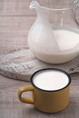 Pitcher, yellow cup of kefir and a white stand