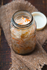 Sauerkraut in a glass jar on a rustic napkin