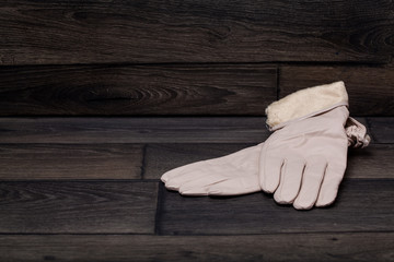 White women's gloves. On a dark wooden background. Winter. For your design.