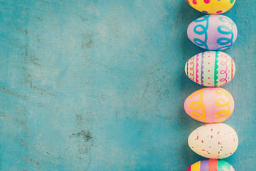 Colorful easter egg on blue pastel color wood background with sp