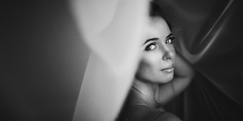 Woman with deep shiny eyes looks over her shoulder standing unde