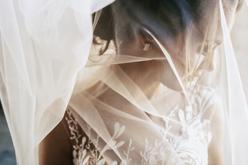 Light veil hides tender young bride
