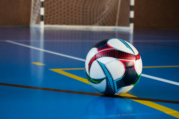 Soccer ball on the floor in the gym against the gate