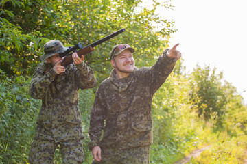 Hunters in camouflage and a gun