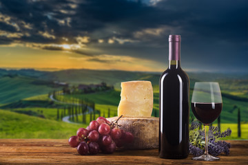 Red wine in vintage light with cheese and fruits.